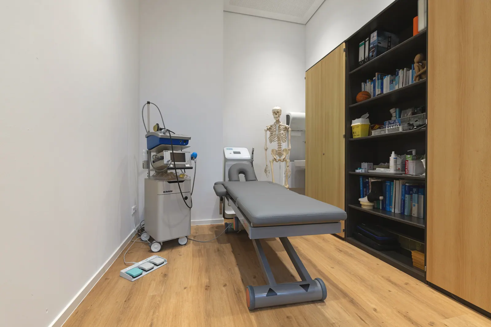 Moderner Behandlungsraum mit Liege und Stoßwellengerät in der Orthopädie-Praxis Bietigheim-Bissingen